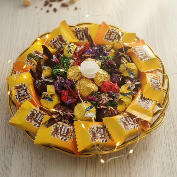 Assorted candies in a decorative tray on a light wooden surface