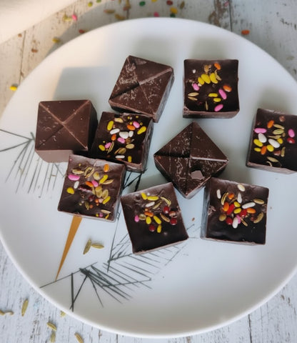 Chocolate squares with colorful toppings on a decorative plate